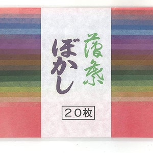 May include: A pack of 20 sheets of Japanese washi paper in a variety of colors, including blue, purple, green, and brown. The pack is labeled with Japanese characters that translate to "Washi Paper" and "20 Sheets".