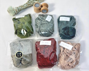 May include: A collection of craft supplies including a long braided cord with tassels, two small wooden spools, and six bundles of thread in various colors, each sealed in a clear plastic bag with a white label, plus one black circular sticker.