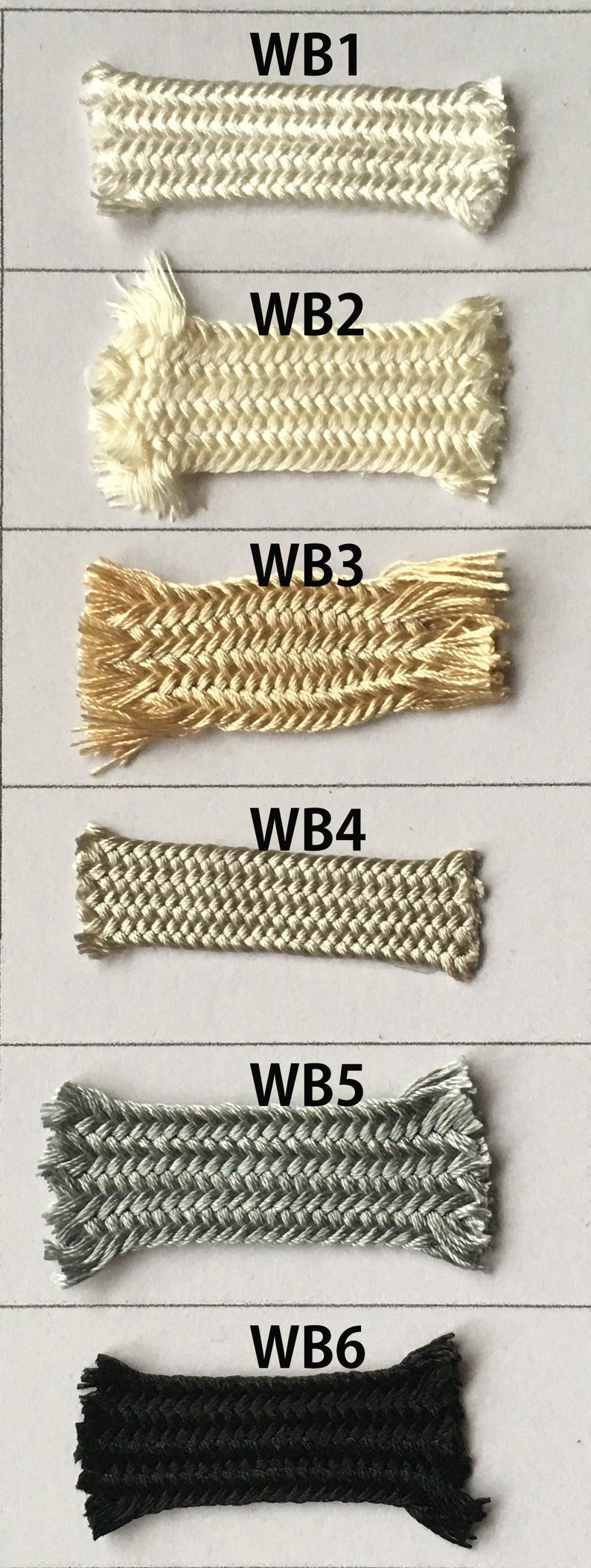 May include: A collection of six braided cords in various colors. The cords are labeled WB1 through WB6. Colors include off-white, beige, gold, light gray, dark gray, and black. Each cord has a frayed edge.