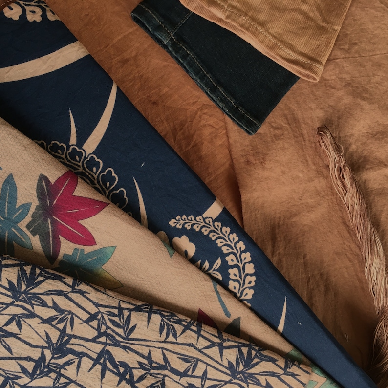 May include: A close-up of a fabric with a blue and white floral pattern. The fabric is layered on top of a brown fabric with a textured surface.