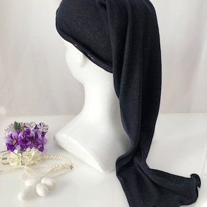 May include: A black knitted sleep cap with a long tail. The cap is on a white mannequin head.