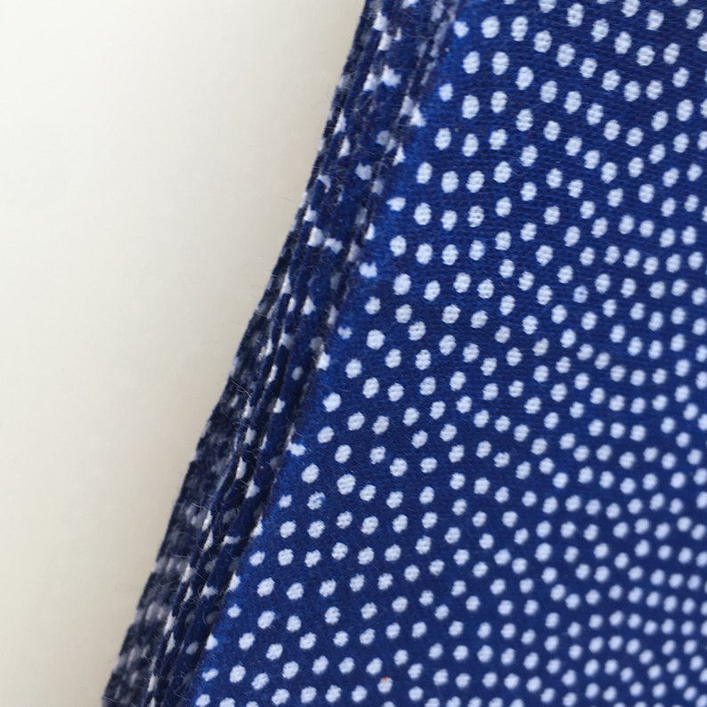 May include: A stack of blue fabric with a white polka dot pattern.