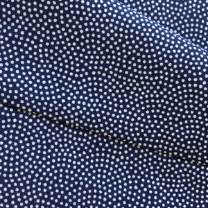 May include: A close-up of a blue fabric with a white polka dot pattern.