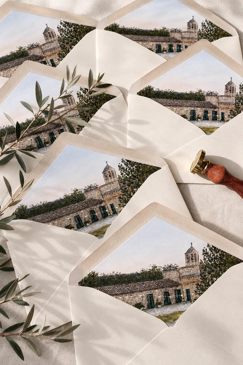 May include: A collection of cream-coloured envelopes with custom envelope liners featuring a watercolour illustration of a stone building with a bell tower, green doors, and string lights, accompanied by a brass wax seal stamp with a wooden handle.