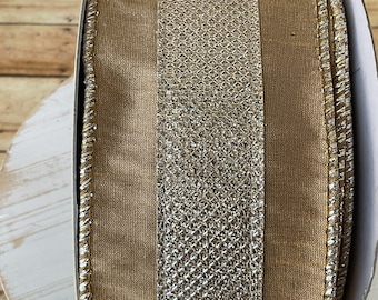 Puede incluir: Un rollo de cinta marrón y plateada con textura brillante. La cinta tiene un borde dorado.