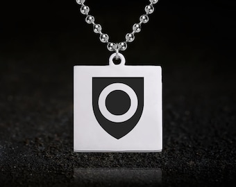May include: Silver-toned pendant necklace featuring a square pendant with a black shield design and a central circle. The necklace has a ball chain and a simple, elegant design. The pendant is approximately 1 inch square.