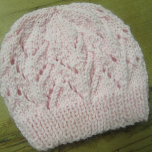 May include: A pink knitted hat with a lacy pattern.