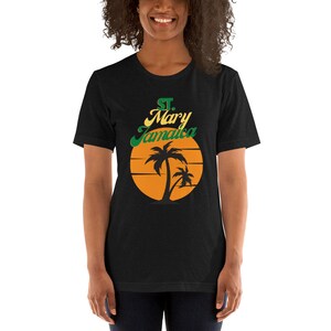 May include: Black t-shirt with a graphic of a sunset with palm trees and the text "St. Mary Jamaica" in green and yellow.