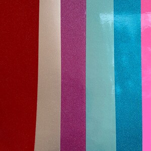 May include: Six vertical strips of glitter paper in different colors: red, beige, pink, light blue, teal, and pink.