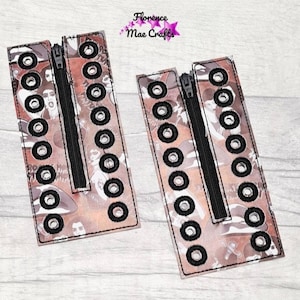 May include: Two brown fabric zippered panels with black eyelets and a black zipper. The panels have a white and brown patterned design.