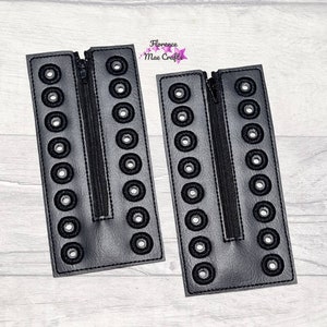 May include: Two black leather zippered panels with rows of black eyelets. The panels are sewn together with a black zipper.