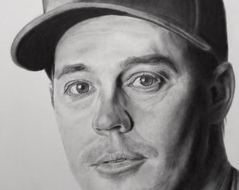 Può includere: Un disegno a matita in bianco e nero di un uomo che indossa un cappello da baseball con la lettera "A" su di esso. L'uomo sta guardando direttamente lo spettatore. Il disegno è firmato "Jacob Burgess Drawings".