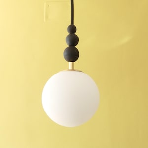 Black and white ball pendant in opaline brass and burnt wood glass Decoration