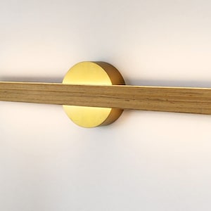 Linear wall light in black and gold beech