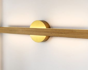 Linear wall light in black and gold beech