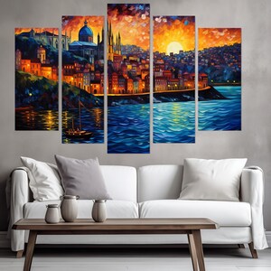 K&ouml;nnte beinhalten: Ein f&uuml;nfteiliges Leinwandbild-Set, das eine farbenfrohe Stadtlandschaft mit einem gro&szlig;en Geb&auml;ude im Zentrum, einem Sonnenuntergang &uuml;ber der Stadt und einem Gew&auml;sser im Vordergrund zeigt. Die Stadt ist in Orange-, Gelb- und Blaut&ouml;nen gemalt, mit einem Boot im Wasser.