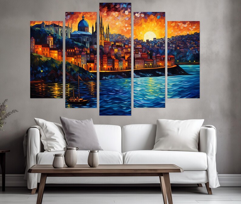 K&ouml;nnte beinhalten: Ein f&uuml;nfteiliges Leinwandbild-Set, das eine farbenfrohe Stadtlandschaft mit einem gro&szlig;en Geb&auml;ude im Zentrum, einem Sonnenuntergang &uuml;ber der Stadt und einem Gew&auml;sser im Vordergrund zeigt. Die Stadt ist in Orange-, Gelb- und Blaut&ouml;nen gemalt, mit einem Boot im Wasser.