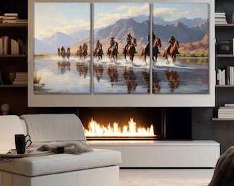 Op de afbeelding: Een meerpaneels canvasprint die een groep cowboys laat zien die op paarden door een ondiep waterlichaam rijden. De cowboys dragen traditionele westerse kleding en de paarden zijn bruin en wit. De achtergrond toont een bergketen en een blauwe lucht.