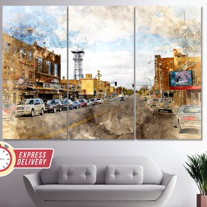 Puede incluir: Una pintura de acuarela de una escena de calle de la ciudad con edificios, coches y un ambiente vintage. Los edificios están pintados en tonos de amarillo, marrón y rojo, y los coches están pintados en tonos de gris y blanco. La calle está pintada en tonos de gris y marrón, y el cielo está pintado en tonos de azul y blanco.