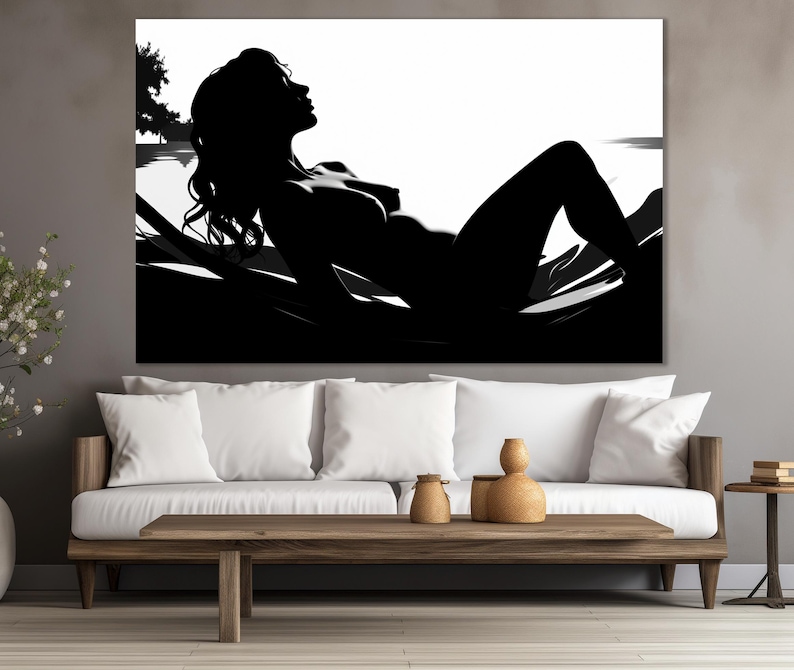 May include: Black and white silhouette of a person lying down on a bed of leaves. The person's hair is long and flowing, and their body is relaxed and at ease. The image is simple and elegant, and it evokes a sense of peace and tranquility.