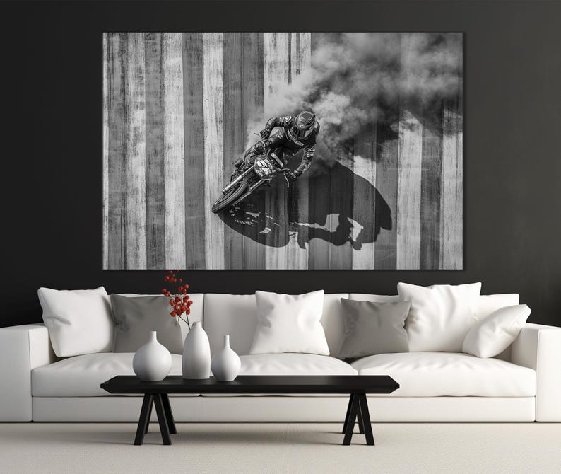 Pu&ograve; includere: Fotografia in bianco e nero di un motociclista in curva, che crea una nuvola di fumo. Lo sfondo presenta strisce verticali in tonalit&agrave; di grigio e bianco. Il pilota indossa un casco e un'attrezzatura protettiva.