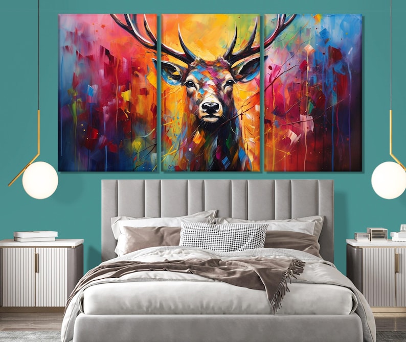 May include: A colourful abstract painting of a deer with large antlers. The deer is painted in shades of red, orange, yellow, green, blue, and purple. The background is a blur of colours.