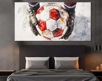 Puede incluir: Una pintura de acuarela de un balón de fútbol sostenido por manos enguantadas. El balón es rojo, blanco y negro con una superficie desgastada y texturizada. El fondo es azul claro con salpicaduras de acuarela blancas y grises.