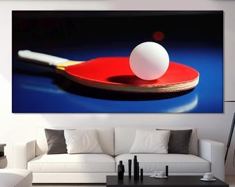May include: A red and black ping pong paddle with a white ping pong ball on top of it. The paddle and ball are on a blue surface.