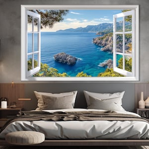 Puede incluir: Un marco de ventana blanco con vista a un océano azul y una costa rocosa. La ventana está abierta y la vista está enmarcada por árboles verdes.