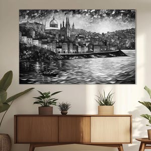 K&ouml;nnte beinhalten: Ein Schwarzwei&szlig;bild einer Stadtlandschaft mit einer Kirche im Zentrum. Die Stadt liegt auf einem H&uuml;gel mit Blick auf ein Gew&auml;sser. Ein kleines Boot befindet sich im Wasser.