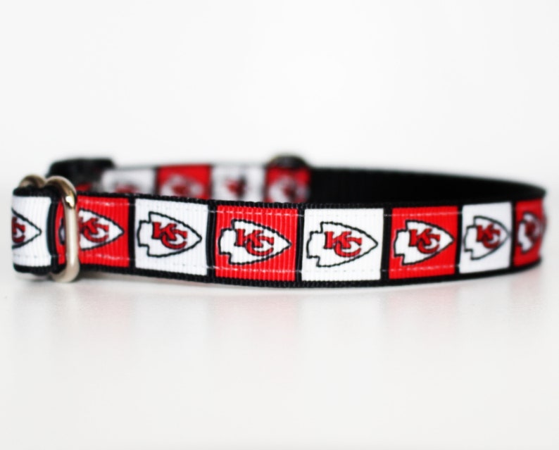 Peut inclure: Un collier de chien rouge, blanc et noir avec un motif r&eacute;p&eacute;t&eacute; du logo des Chiefs de Kansas City.