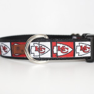 Peut inclure: Un collier de chien noir avec un motif rouge, blanc et noir repr&eacute;sentant le logo des Kansas City Chiefs. Le collier a un anneau en D en m&eacute;tal argent&eacute;.
