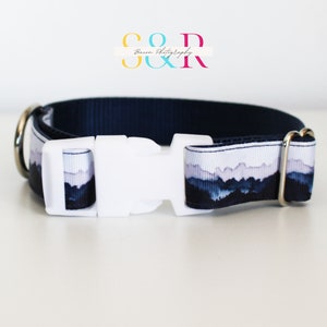 K&ouml;nnte beinhalten: Ein marineblaues Hundehalsband mit einem wei&szlig;en Bergpanorama-Druck und einer wei&szlig;en Kunststoffschnalle. Das Halsband hat silberne Metall-D-Ringe.