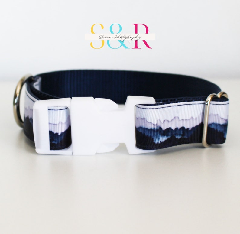 K&ouml;nnte beinhalten: Ein marineblaues Hundehalsband mit einem wei&szlig;en Bergpanorama-Druck und einer wei&szlig;en Kunststoffschnalle. Das Halsband hat silberne Metall-D-Ringe.