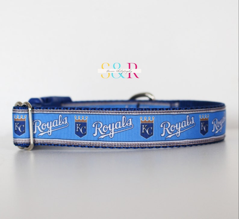 Puede incluir: Un collar para perro azul y blanco con el logotipo de los Kansas City Royals y la palabra "Royals" repetida en el collar.