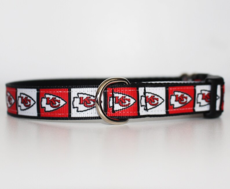 Peut inclure: Un collier de chien noir avec un ruban &agrave; motif rouge, blanc et noir repr&eacute;sentant le logo des Kansas City Chiefs.