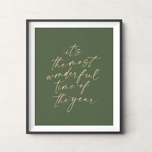 Könnte beinhalten: Ein gerahmter Druck mit grünem Hintergrund und goldenem Text, der "Es ist die schönste Zeit des Jahres" lautet.