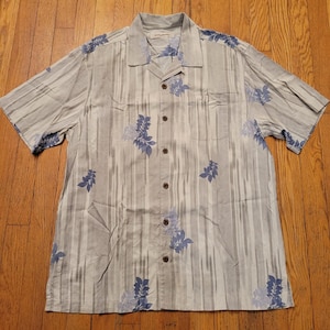 Camisa Tommy Bahama L de seda con botones, rayas azules y estampado floral, ideal para el verano y la playa.