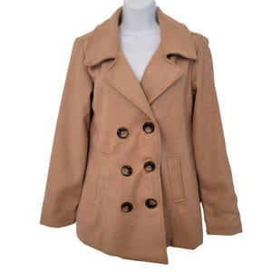 May include: A tan double-breasted coat with six dark brown buttons. The coat has a notched collar, two front pockets, and long sleeves. The coat is displayed on a white mannequin.