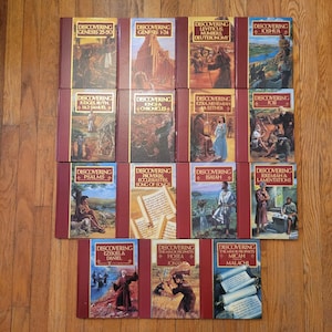 Op de afbeelding: Een verzameling van veertien gebonden boeken met de titel Discovering, elk voorzien van een kastanjebruine rug en rand met een centrale illustratie van bijbelse scènes, waaronder Genesis, Psalmen, Jesaja en de kleine profeten.