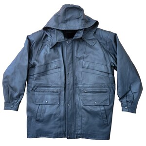 May include: A black leather jacket with a hood. The jacket has multiple pockets, including two chest pockets and two lower pockets. It features a button-up front and buttoned cuffs. The jacket is designed for outerwear and protection from the elements.