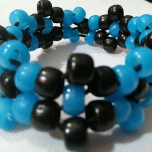 May include: A black and blue beaded bracelet with a woven pattern. The bracelet is made of small, round beads.