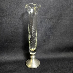 May include: A clear glass vase with a ruffled top and a silver-colored metal base. The vase has an etched wheat design. The vase is approximately 10 inches tall.