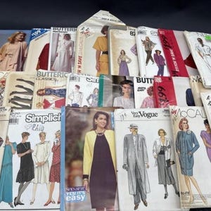 May include: A collection of vintage sewing patterns from various brands, including Butterick, Vogue, and McCall's. The patterns feature illustrations of dresses, suits, and other garments. The covers display models in various styles and colors, with text such as "Simplicity" and "Stitch 'N Save".