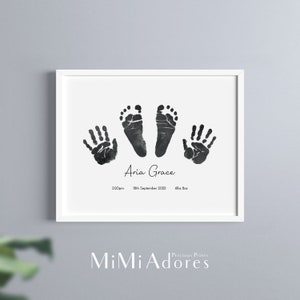 K&ouml;nnte beinhalten: Ein gerahmter Schwarzwei&szlig;druck von Babyhand- und Fu&szlig;abdr&uuml;cken. Der Druck enth&auml;lt den Namen "Aria Grace", das Datum "2:20pm 18th September 2022" und das Gewicht "6lbs 8oz".
