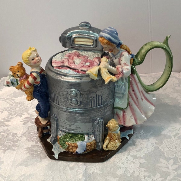 Vintage Wash Day Teapot, Mom washing baskets of laundry in old fashioned wringer washer. Son and kitty are watching. 11" wide x 8.5" tall