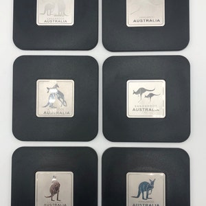 May include: Six black square coasters with silver metallic insets featuring a kangaroo silhouette and the text "Kangaroos Australia".