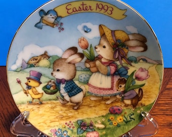 Prato colecionável de 12,7 cm (5") da Avon, "Desfile de Páscoa", 1993. Animais encantadores em um desfile de Páscoa. Porcelana com detalhes em ouro 22 quilates.