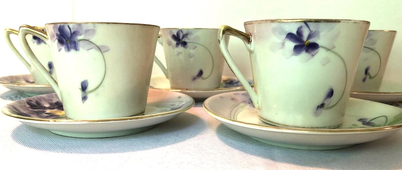 Zeldzame antieke Nippon handgeschilderde porseleinen theekopjes en schoteltjes. Violet, groen en geel uit de jaren 40 met gouden rand. Set van 5. In goede staat. afbeelding 2