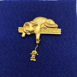 Gold Tone Cat and Mouse Brooch by J J.  Cat on a shelf holding mouse by the tail.  2 3/8&quot; wide x 2.5&quot; long including mouse.